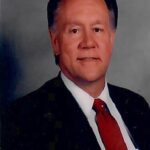 Formal photo of Dr. Jerry Ramsey in a suit and tie